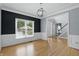 Dining room with modern light fixture, chair rail molding, hardwood floors, and a view to the entry and staircase at 9703 Fortune Dr, Fishers, IN 46037