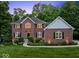 Beautiful brick home with manicured landscaping and a spacious three-car garage, dusk lighting at 9703 Fortune Dr, Fishers, IN 46037