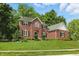 Attractive two-story brick house with manicured lawn and mature trees in a suburban setting at 9703 Fortune Dr, Fishers, IN 46037