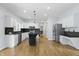 Bright kitchen with stainless steel appliances, island, white cabinetry, and hardwood flooring at 9703 Fortune Dr, Fishers, IN 46037