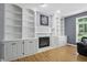 Bright living room featuring a fireplace, built-in shelving, and large windows at 9703 Fortune Dr, Fishers, IN 46037