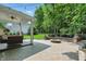 Covered brick patio with outdoor seating, fire pit, and manicured backyard at 9703 Fortune Dr, Fishers, IN 46037