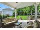 Covered outdoor patio featuring wicker furniture and a view of the landscaped backyard at 9703 Fortune Dr, Fishers, IN 46037