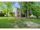 Backyard with a two-story home, well manicured lawn, and mature trees at 10402 Shakamak Way, Indianapolis, IN 46239