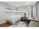 Cozy bedroom features a shelf, large window, neutral walls and patterned bedding at 10402 Shakamak Way, Indianapolis, IN 46239