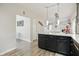 Open concept kitchen featuring dark cabinets, modern lighting, and seamless access to other living areas at 10402 Shakamak Way, Indianapolis, IN 46239