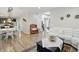 Bright living room featuring a white sofa, hardwood floors, and an open view to the kitchen and stairway at 10402 Shakamak Way, Indianapolis, IN 46239