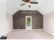 Vaulted ceiling bedroom featuring dark-stained wood accent wall and large window at 106 N Blake St, Sheridan, IN 46069