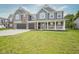 Charming two-story home featuring gray siding, brick accents, a welcoming front porch, and a two-car garage at 10903 Greenleaf Dr, Indianapolis, IN 46229