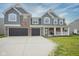 Charming two-story home featuring gray siding, brick accents, a welcoming front porch, and a two-car garage at 10903 Greenleaf Dr, Indianapolis, IN 46229