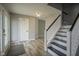 Open foyer with updated flooring, staircase with black and white railing, and access to the living spaces at 10903 Greenleaf Dr, Indianapolis, IN 46229