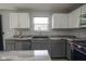 Modern kitchen with stainless steel appliances, gray cabinets, white upper cabinets and unique counters at 10903 Greenleaf Dr, Indianapolis, IN 46229