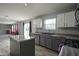 Modern kitchen with stainless steel appliances, island, gray cabinets, and sliding doors to the backyard at 10903 Greenleaf Dr, Indianapolis, IN 46229
