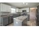 Modern kitchen with stainless steel appliances, gray cabinets, and kitchen island, adjacent to living room at 10903 Greenleaf Dr, Indianapolis, IN 46229