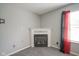 Close-up of fireplace in living room with a black and red sheer curtain over a window at 10903 Greenleaf Dr, Indianapolis, IN 46229