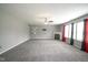 Spacious living room with a fireplace, ceiling fan, large windows, and modern gray carpeting at 10903 Greenleaf Dr, Indianapolis, IN 46229