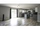 View of the kitchen, island, and living room. Modern design with gray walls and wood-look flooring at 10903 Greenleaf Dr, Indianapolis, IN 46229