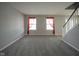 Bright living room with neutral carpet, large windows with red curtains, and fresh gray paint at 10903 Greenleaf Dr, Indianapolis, IN 46229