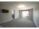 Bright living room with neutral carpet, large windows with red curtains, and fresh gray paint at 10903 Greenleaf Dr, Indianapolis, IN 46229