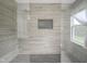 Modern tiled shower with dual shower heads, glass enclosure and integrated storage niche at 10903 Greenleaf Dr, Indianapolis, IN 46229