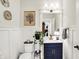 Charming powder room featuring blue vanity, decorative accents, and wainscoting at 1135 Maclaren Ct, Franklin, IN 46131