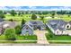 Stunning exterior view of a gray two-story home on a well-manicured lawn with a golf course in the background at 1135 Maclaren Ct, Franklin, IN 46131