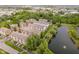 Overhead shot featuring brick townhomes beside a pond, surrounded by mature trees and landscaping at 11872 Salerno Ct, Carmel, IN 46032