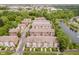 Aerial view of well-maintained townhomes with lush greenery and a tranquil pond with fountain features at 11872 Salerno Ct, Carmel, IN 46032