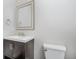 Bathroom with a dark vanity cabinet, white sink and toilet, and framed mirror at 11872 Salerno Ct, Carmel, IN 46032