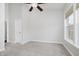 A bright bedroom offers neutral carpet, a ceiling fan, a door, a window, and neutral paint at 11872 Salerno Ct, Carmel, IN 46032