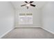 A bright bedroom features a ceiling fan, a neutral carpet, and a window offering lots of natural light at 11872 Salerno Ct, Carmel, IN 46032