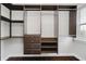 This walk-in closet has custom dark brown storage with drawers, shelving, and hanging racks near a window at 11872 Salerno Ct, Carmel, IN 46032