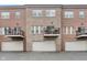 A townhome exterior features a brick facade with balconies over individual garages in a well-kept community at 11872 Salerno Ct, Carmel, IN 46032