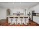 Open kitchen featuring granite countertops, seating at island, stainless steel appliances and hardwood floors at 11872 Salerno Ct, Carmel, IN 46032
