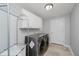 This laundry room features a washer and dryer with lots of cabinetry and a drying rack at 11872 Salerno Ct, Carmel, IN 46032