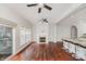 Open-concept living room with fireplace, windows, ceiling fans, and hardwood floors adjacent to kitchen at 11872 Salerno Ct, Carmel, IN 46032