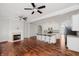 Open-concept living area with fireplace, ceiling fans, hardwood floors, and a kitchen with a center island at 11872 Salerno Ct, Carmel, IN 46032