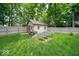 Large backyard featuring a shed, garden beds, and green grass at 1304 Old Hickory Cir, Greenwood, IN 46142