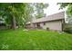 Lush green backyard with mature trees, a deck, and manicured lawn at 1304 Old Hickory Cir, Greenwood, IN 46142