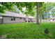 Spacious backyard with a deck, mature trees, and green grass at 1304 Old Hickory Cir, Greenwood, IN 46142