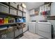 Well-organized laundry room with shelves, storage bins, washer, and dryer at 1304 Old Hickory Cir, Greenwood, IN 46142