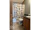 Well kept bathroom with wood vanity, toilet and shell designed shower curtain at 135 Sunset Ct, Cicero, IN 46034