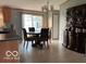 Dining room with seating for four, modern lighting, and decorative shelving unit at 135 Sunset Ct, Cicero, IN 46034