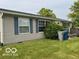 Home exterior with blue shutters and lush lawn; trash cans by the home at 135 Sunset Ct, Cicero, IN 46034