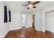 Bedroom featuring hardwood floors, ceiling fan, neutral walls, built in book shelves and ensuite bath at 1410 Lawrence Ave, Indianapolis, IN 46227