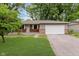 Charming single-story home featuring a brick facade, attached garage, and well-maintained lawn at 1410 Lawrence Ave, Indianapolis, IN 46227