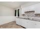 Functional kitchen featuring tile floors, white cabinets, stone counter tops, and stainless steel sink at 1410 Lawrence Ave, Indianapolis, IN 46227