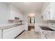Bright kitchen featuring white cabinets and appliances, with mosaic backsplash and tile flooring at 1410 Lawrence Ave, Indianapolis, IN 46227