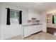 Bright kitchen featuring white cabinets and appliances, with mosaic backsplash and tile flooring at 1410 Lawrence Ave, Indianapolis, IN 46227