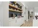 Coffee bar area features custom shelving with dark accent wall, white cabinets, and light wood floors at 16244 Perrault Ct, Fishers, IN 46040